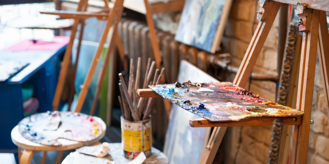 Staffeleien, Malerpaletten, Pinsel in einem Atelier.